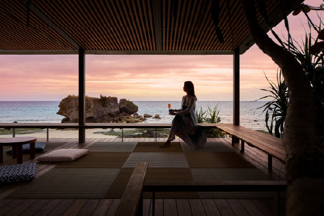 屋根付きの海辺のテラスから望む夕陽