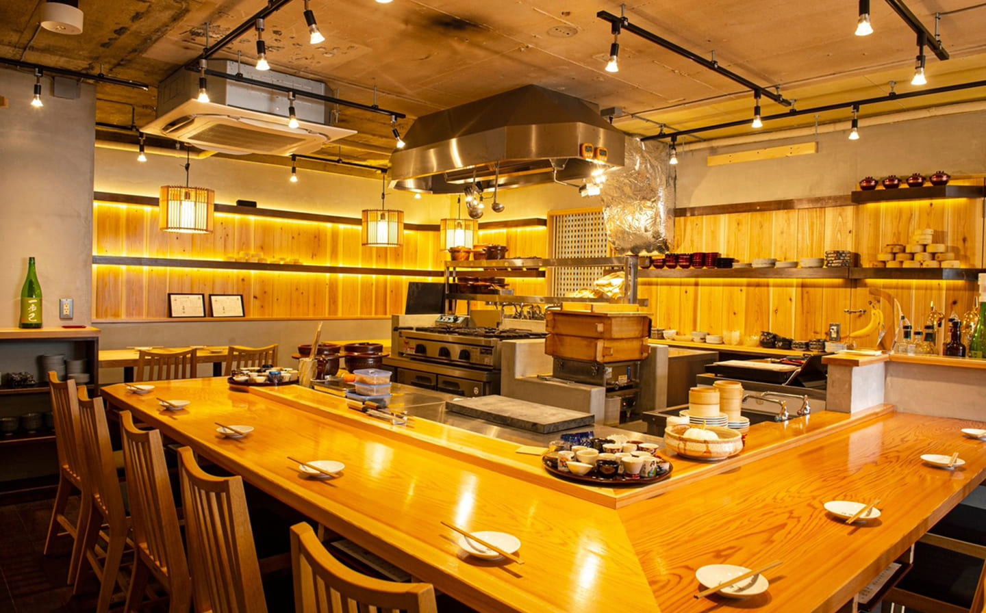 木の温もりを感じるモダンな店内。調理の様子を見られるカウンターは特等席