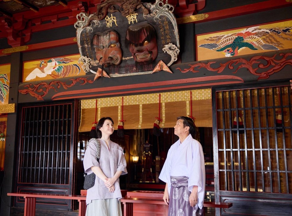 大杉神社で宮司さんの話を聞く美村里江さん