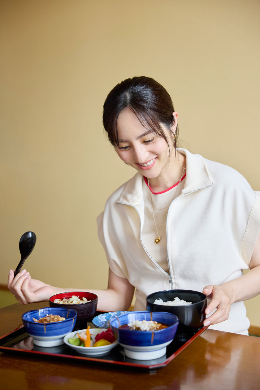 宿の食事トレイを手に微笑む堀田茜