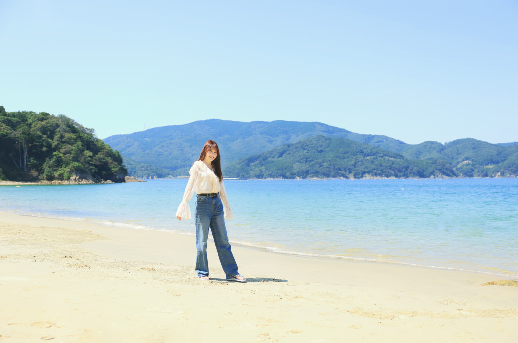 夏浜のビーチを歩く久間田琳加さん