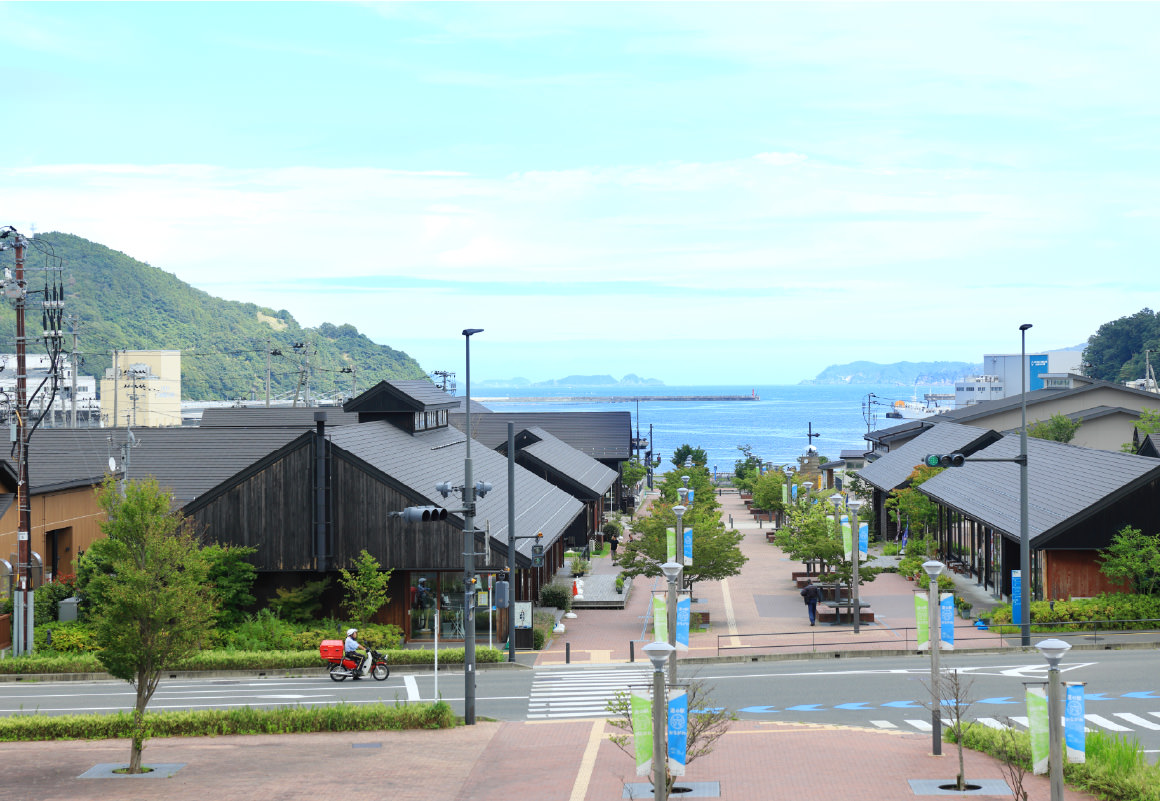記念フラッグが並ぶ女川駅前レンガみちと女川湾の眺め