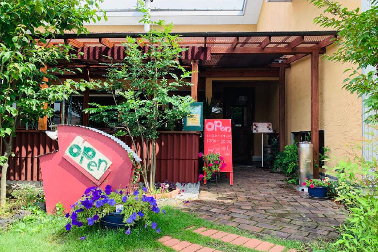 緑に囲まれたカフェのような外観。テラス席ではペットも一緒に過ごすことができる