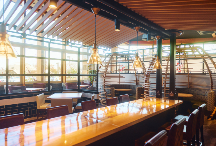 木の質感を生かしたナチュラルな雰囲気の店内。奥の席では900mlの牛乳瓶が照明に使われている