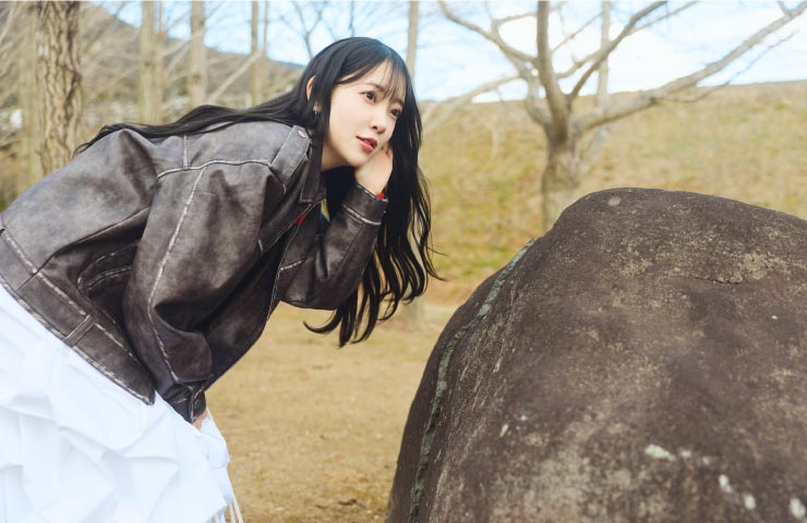 石の割れ目に近づき朗読に耳を傾ける堀さん。「向こう側に誰かがいるみたい」