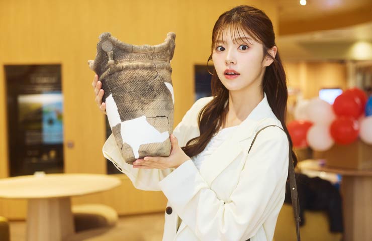 約5000年前に作られた土器を恐る恐る持ち上げ「ずっしりしてる」と質感を教えてくれた鈴木さん。※土器に触れられるのはイベント開催時のみ