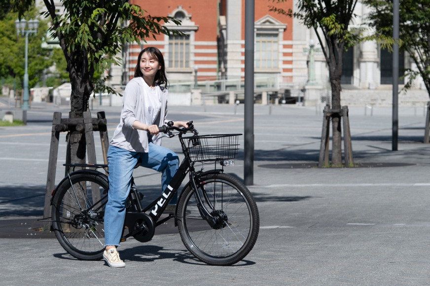 PELTECHの電動アシスト自転車に乗って出かける女性