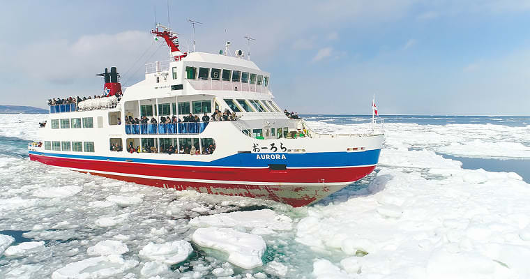 流氷を砕きながら進む観光船の写真
